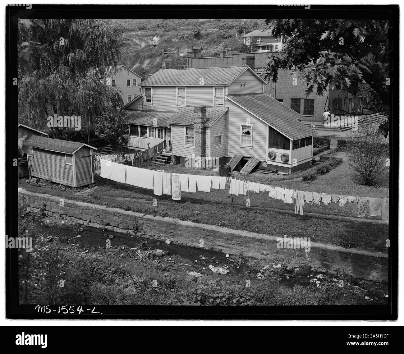 Une scène d'arrière-cour montre des prieurés et des maisons de charbon dans une communauté minière. La photographie met en évidence les conditions insalubres causées par le drainage des déchets dans un petit ruisseau. Banque D'Images