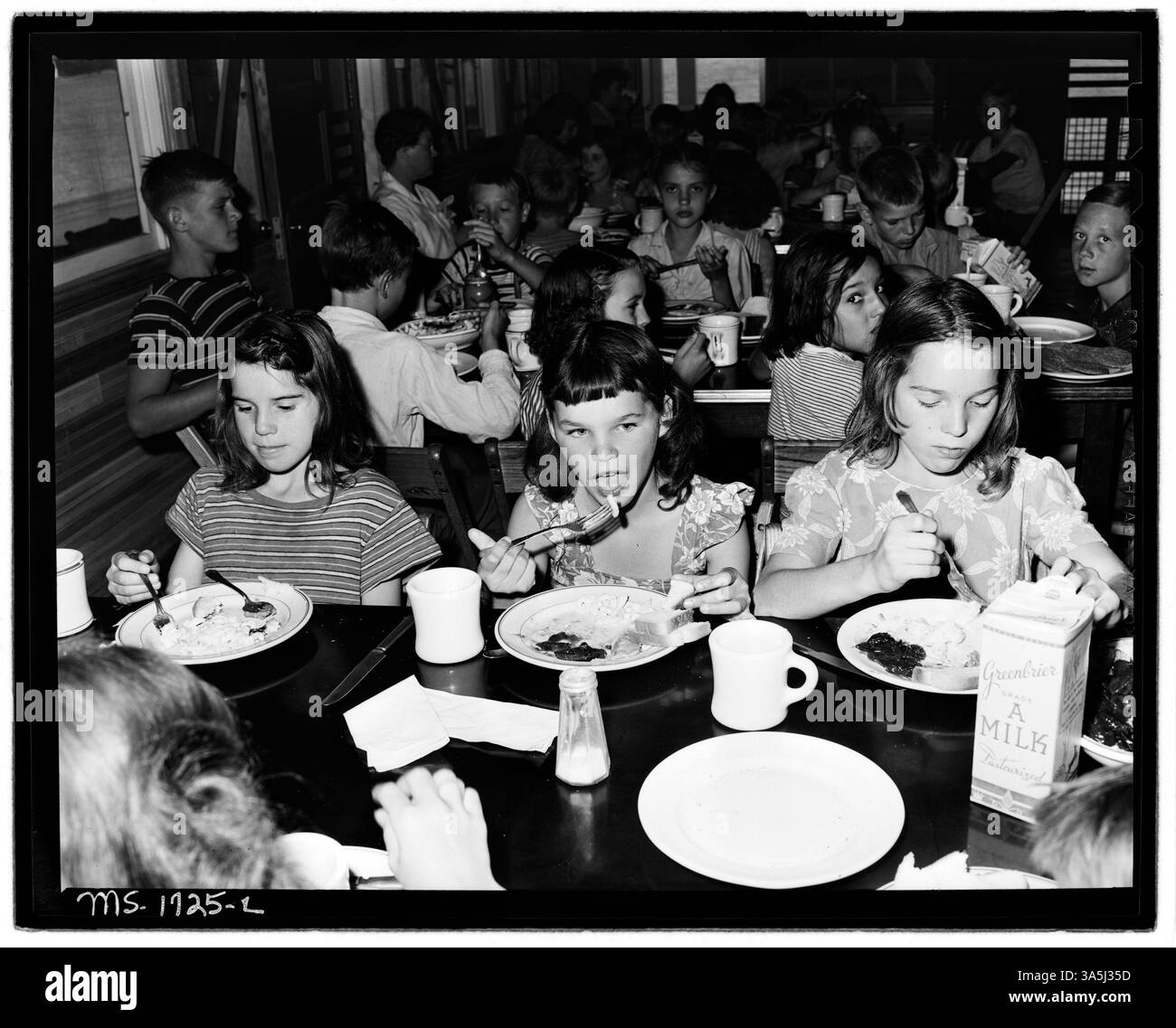 Cette photographie montre des enfants au Camp Thomas E. Lightfoot à Hinton, en Virginie-occidentale, pendant leur repas de midi. Le repas se compose de macaronis et de fromage, une salade de légumes, du beurre d'arachide, du pain et des biscuits, avec du lait disponible en quantités illimitées. Le camp fournit de la nourriture, de l'hébergement et du transport pour une période de deux semaines au coût de 7,00 $. Banque D'Images