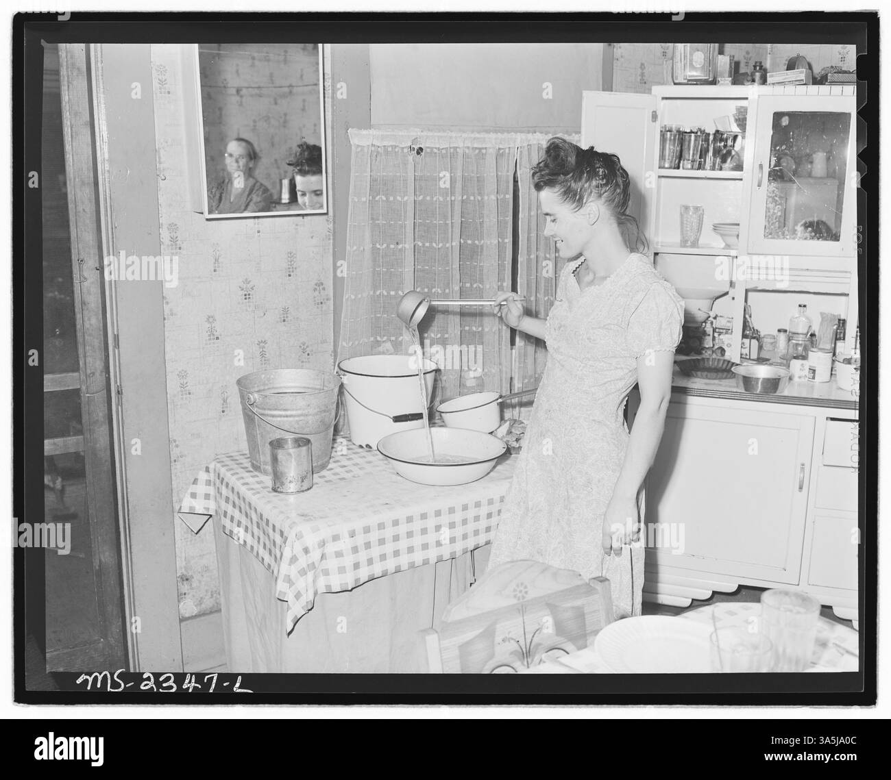 MRS Robert Moffett se tient dans sa cuisine dans sa maison louée près des 30-31 Mines de Black Mountain Corporation à Kenvir, comté de Harlan, Kentucky. Sa famille, y compris ses trois enfants et des membres de sa famille élargie, y vivent depuis deux ans au loyer de 10 $ par mois. Banque D'Images
