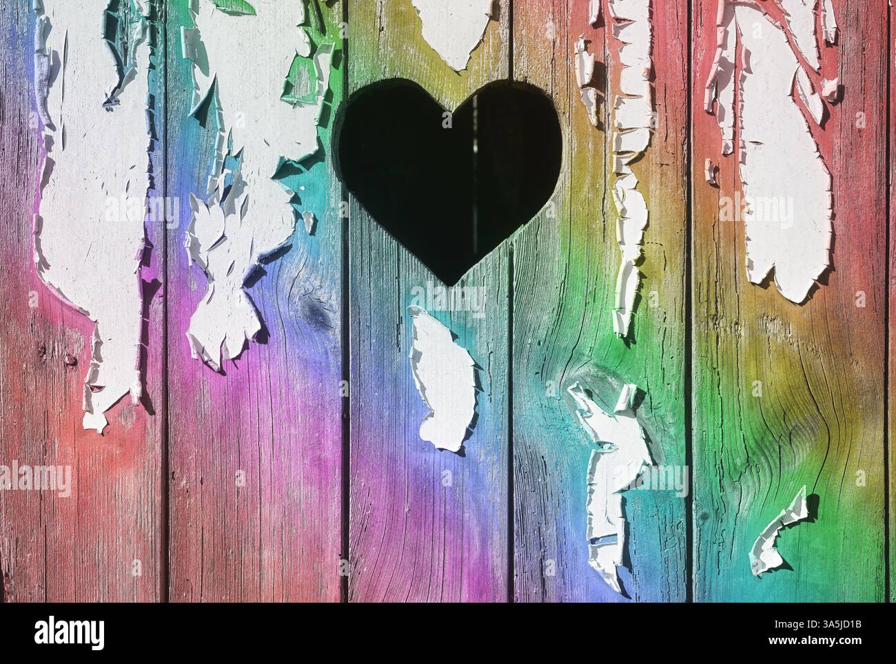 Une forme de coeur découpée dans une planche de bois avec de la peinture pelable. Banque D'Images
