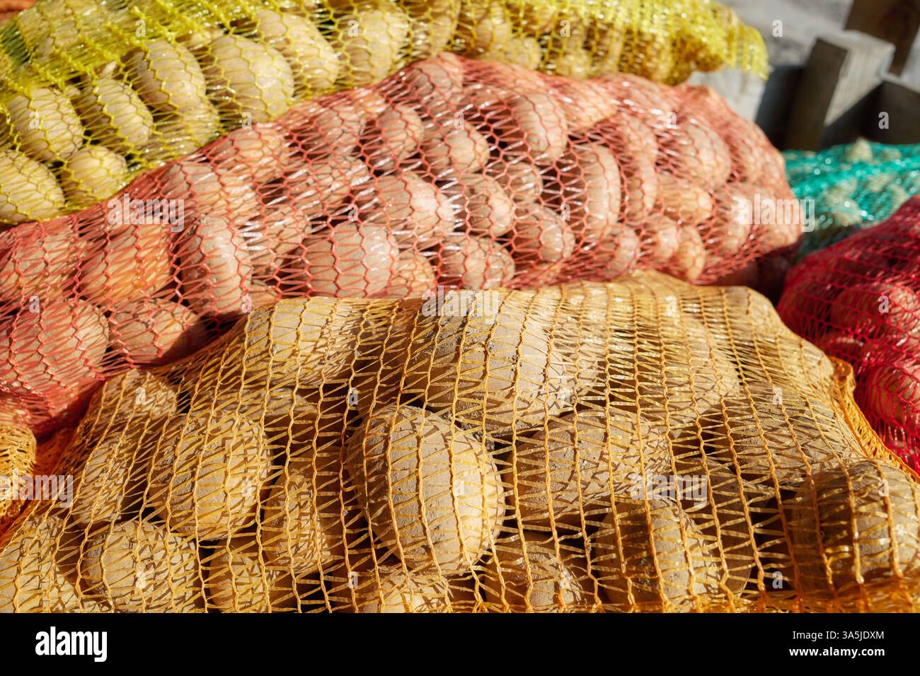 Pommes de terre biologiques dans des sacs nets, focus sélectif. Banque D'Images