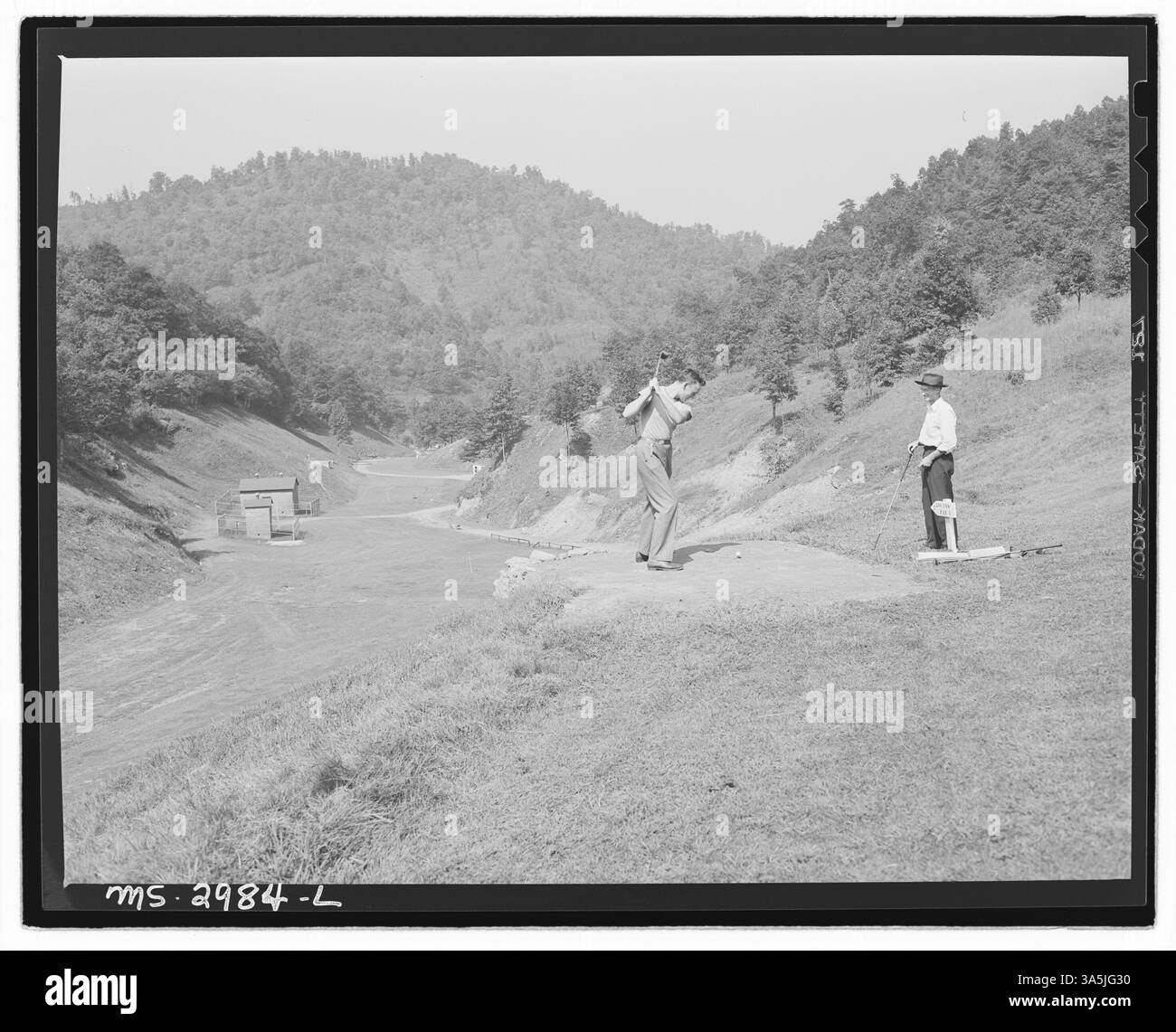 Harry Fain, un chargeur de charbon, et son fils George sont montrés en train de partir sur le terrain de golf de Wheelwright, Kentucky, mettant en vedette un moment récréatif dans la communauté construite autour des mines de l’Inland Steel Company. Banque D'Images