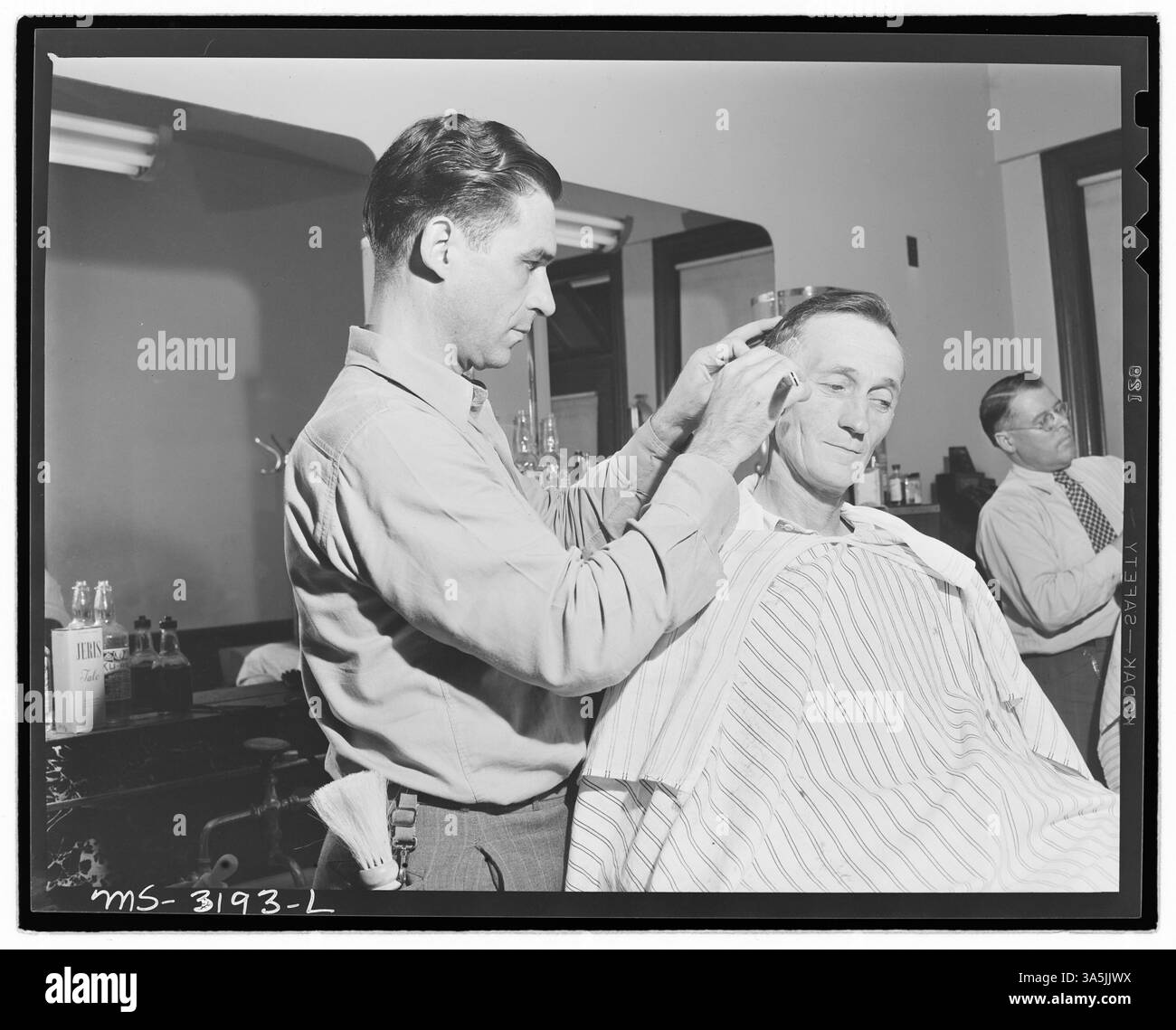 Harry Fain, un chargeur de charbon, se fait couper les cheveux au salon de coiffure du centre communautaire à Wheelwright, Kentucky. Le centre communautaire exploité par la compagnie offrait des services aux mineurs et à leurs familles. Banque D'Images
