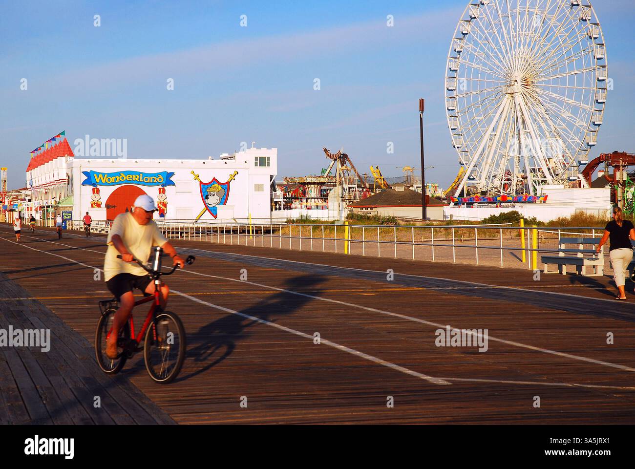 Un homme âgé monte à vélo le long de la promenade à Ocean City, New Jersey Banque D'Images