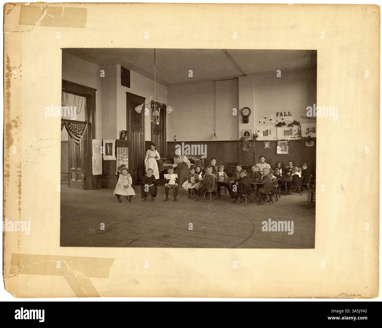 Une vue intérieure de la salle de maternelle dans le bâtiment Old main de l'Université d'État de Cloud à offert Cloud, Minnesota. La salle montre des enfants assis à des tables et des chaises, avec des femmes debout et assises en arrière-plan. Old main a été construit en 1874, servant de bâtiment important pour les premiers efforts éducatifs de l'université. Banque D'Images