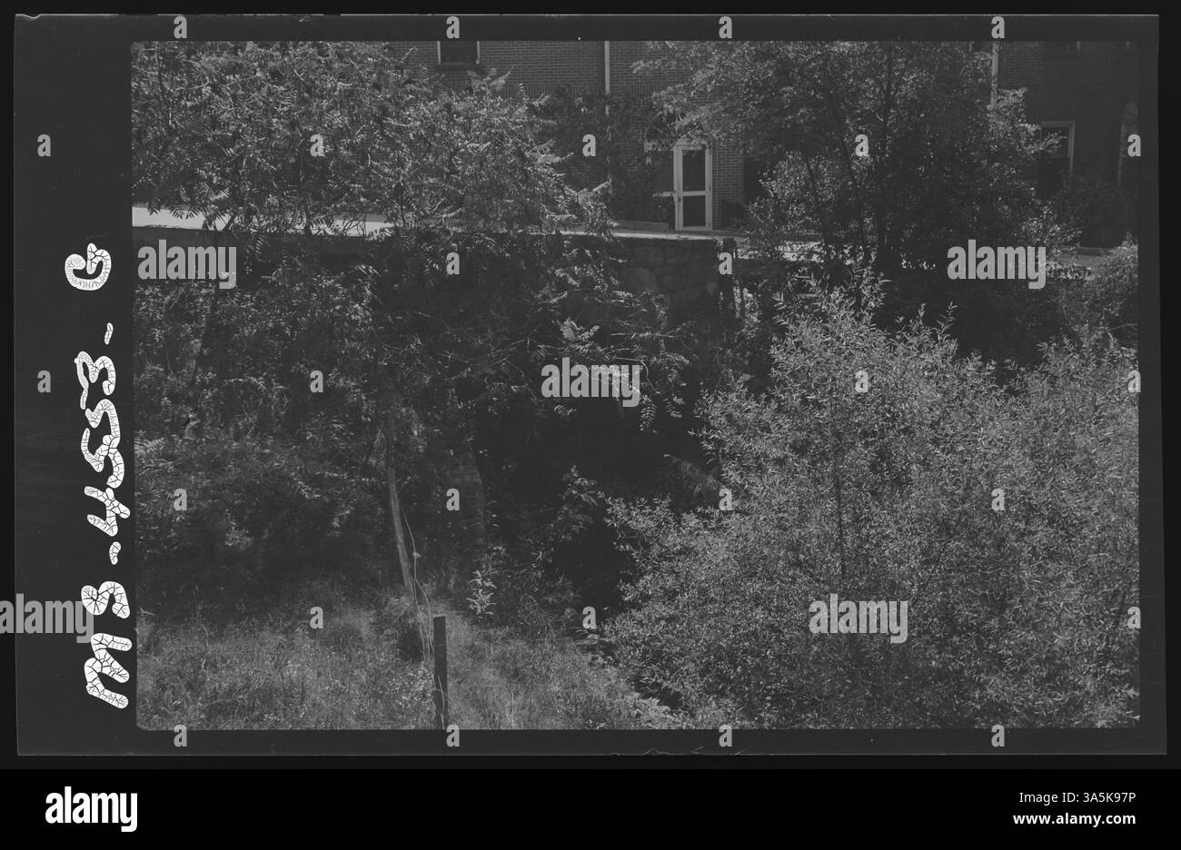 Cette photographie capture la clinique Stevens à Welch, dans le comté de McDowell, en Virginie-occidentale, avec un petit ruisseau au premier plan où les eaux usées non traitées de l'hôpital ont été évacuées. L'image met en évidence les conditions insalubres de l'époque. Banque D'Images