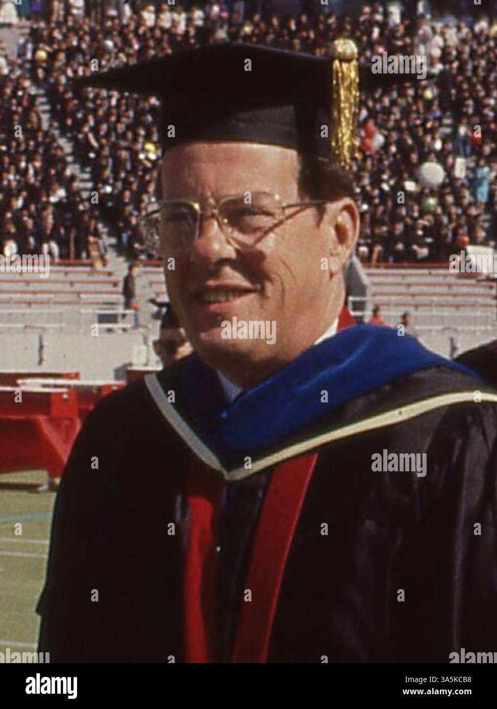 Le président de l'université d'État de l'Ohio, Edward H. Jennings, dirige les membres du corps professoral dans les regalia académiques à travers le terrain de l'Ohio Stadium en 1989. Cette image met en évidence une procession académique formelle, un élément clé des cérémonies universitaires. Banque D'Images