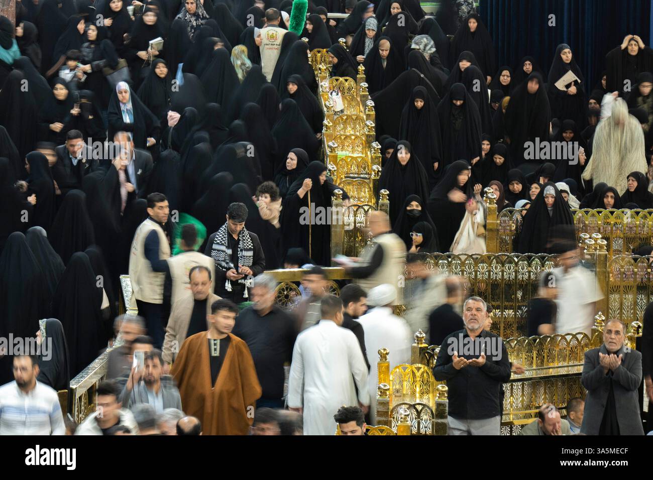 Shiite Muslim pilgrims visit the holy shrine of Imam Abbas during Laylat al-Qadr, or the Night of Destiny, in the holy fasting month of Ramadan in Karbala, Iraq, Sunday, March 23, 2025. (AP Photo/Hadi Mizban) Banque D'Images