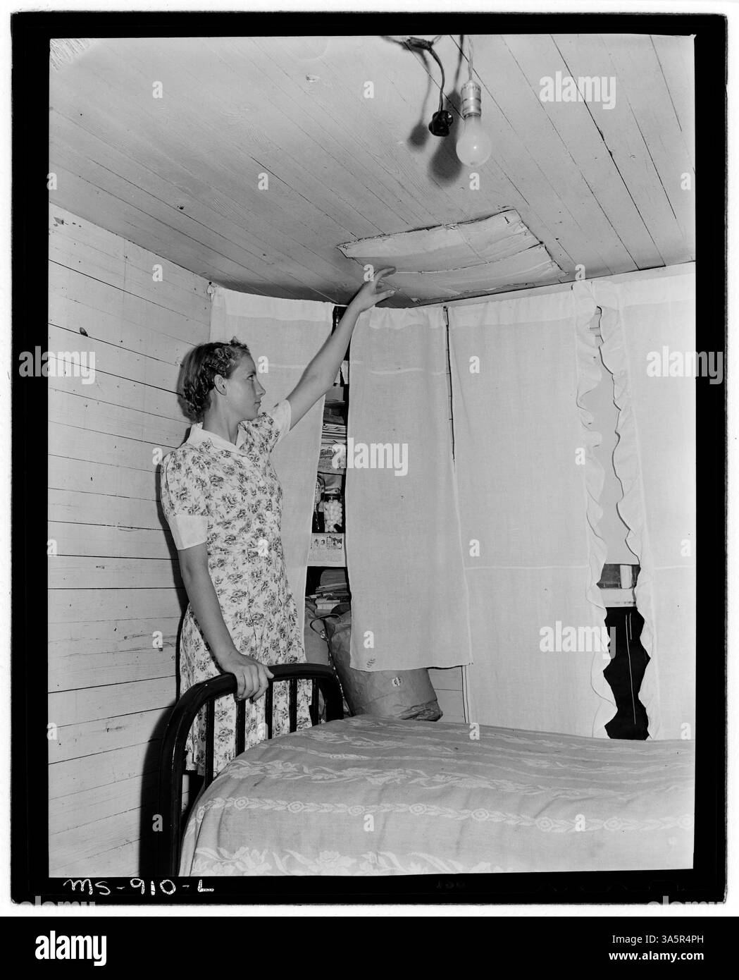 Pauline Murray, la fille d'un mineur, montre une planche de métal dans sa chambre qui empêche les briques de cheminée lâches de tomber. Le conseil d'administration fuit également de l'eau pendant la pluie, soulignant les mauvaises conditions de logement dans les maisons appartenant à la société à la Brilliant Coal Company. Banque D'Images