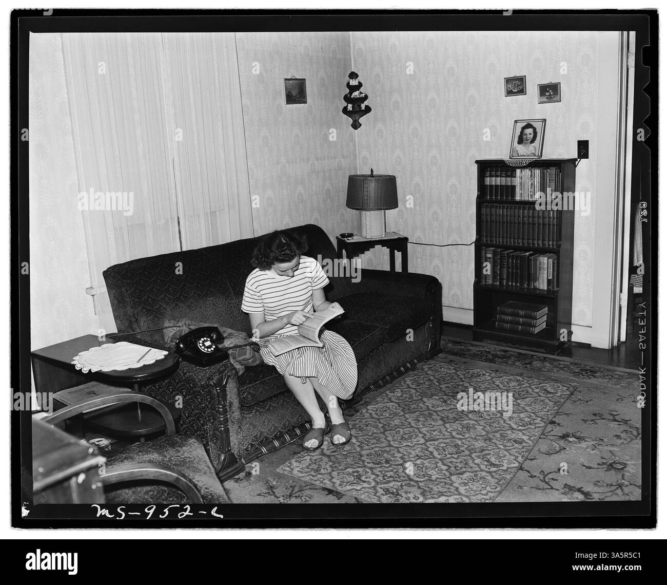 La fille de Cecil Allgood, un mineur, cherche un numéro dans l'annuaire téléphonique de leur domicile dans le projet de logement de l'entreprise près de Tennessee Coal, Iron & R.R. Company's Edgewater mine à Birmingham, Alabama. Banque D'Images