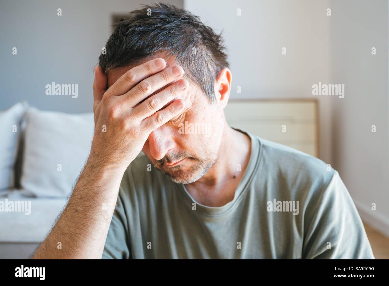 Portrait de tête d'homme triste et déprimé dans le salon, seul à la maison, mise au point sélective Banque D'Images