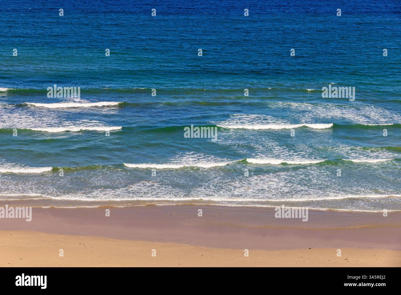 Vagues de mer à une plage de sable fin un jour d'été Banque D'Images