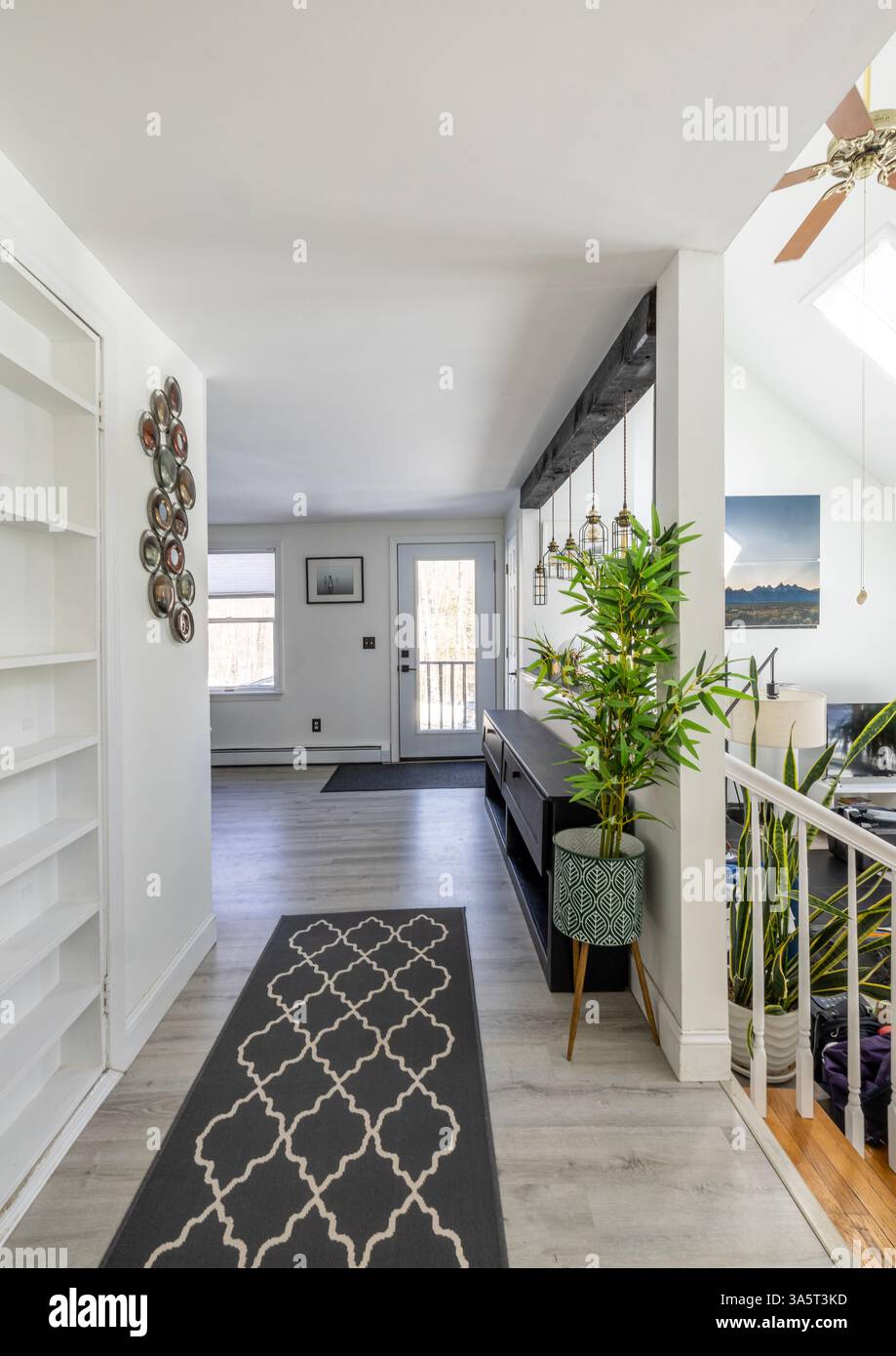 Couloir avec tapis dans la maison moderne légère mène à la porte d'entrée. Banque D'Images