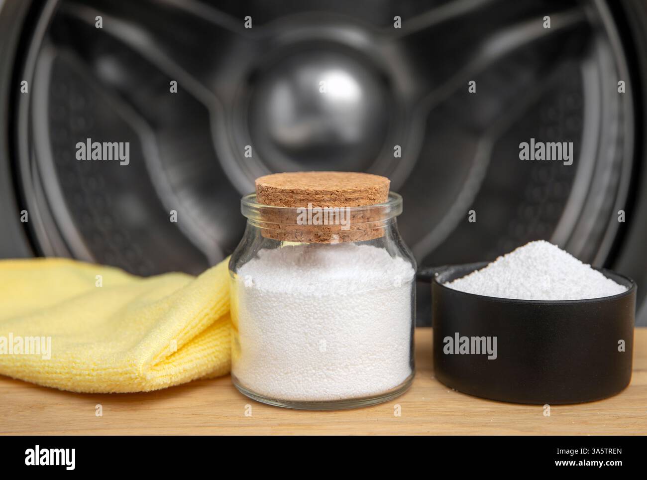 Nettoyage du tambour de machine à laver avec de l'acide citrique. Tasse graduée remplie d'acide citrique et pot en verre, chiffon de lavage contre le tambour de la machine à laver. Banque D'Images