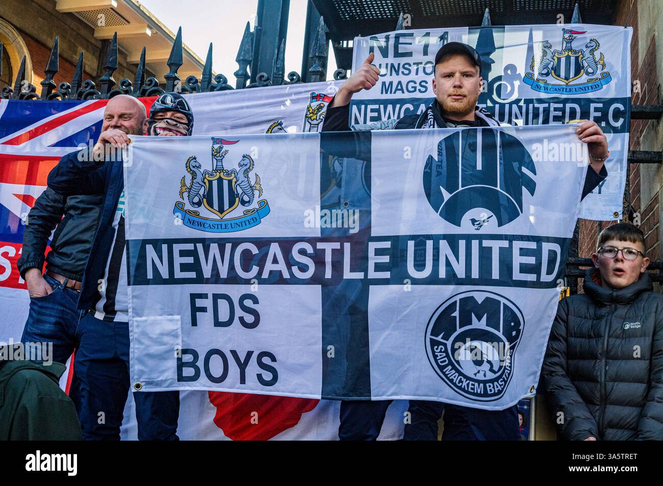 Tenant un drapeau Newcastle United, geste des supporters. Dans l'après-midi du 15 mars, des dizaines de milliers de fans de Newcastle United se déplacent de la ville à Londres pour la finale de la Coupe de la Ligue de Carabao contre Liverpool le lendemain. Sans victoire de trophée national en 70 ans, la 'Toon Army' voyage de Newcastle avec excitation, espoir et pensées de victoire. Les fans de Newcastle se rassemblent à Covent Garden pour une fête la veille de la finale de la coupe, buvant, chantant et riant pour soutenir leur équipe de football bien-aimée. Banque D'Images