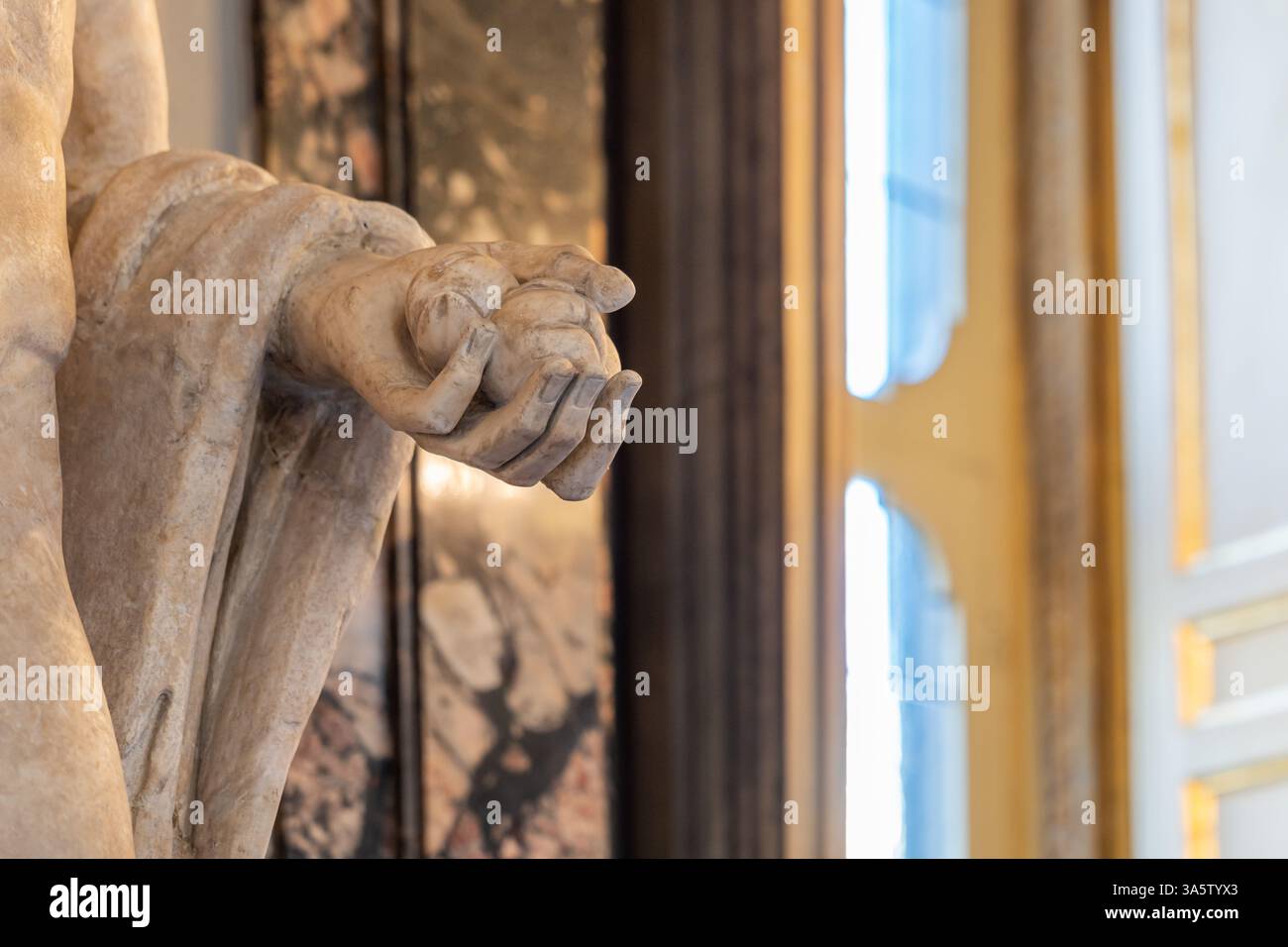 Détail d'une statue en marbre classique représentant une main humaine tenant deux sphères Banque D'Images