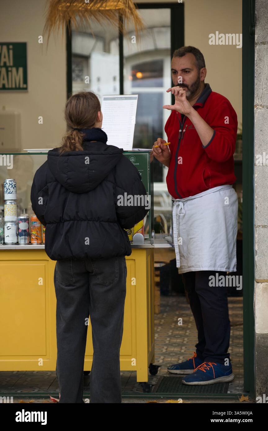 Un fournisseur et un client discutent dans un stand de café, affichant l'hospitalité et le service. Banque D'Images