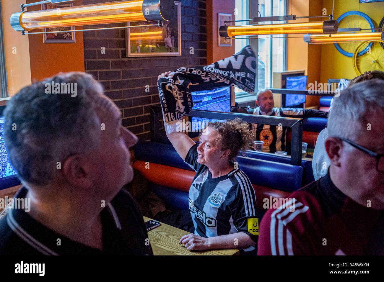 Dans un bar sportif Marylebone, une supporteuse agite son foulard en prévision du coup d'envoi de la finale de la Coupe de la Ligue de Carabao. Dans l'après-midi du 16 mars, des dizaines de milliers de fans de Newcastle United descendent. Wembley Way au stade de Wembley pour la finale de la Coupe de la Ligue de Carabao contre Liverpool. Sans une victoire de trophée domestique en 70 ans, la « Toon Army » marche sur la célèbre route avec excitation, espoir et pensées de victoire. Plus tard dans la journée, les fans de Newcastle sans billet regardent le match dans un événement du Sports Bar organisé par le supporter's Trust dirigé par les fans du club. Après une victoire de 1-2 sur Liverpool, t Banque D'Images