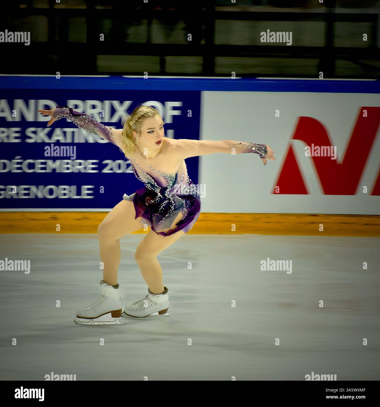 Patineuse artistique Amber Glenn jouant sur la glace dans une robe à sequins violette gracieuse Banque D'Images