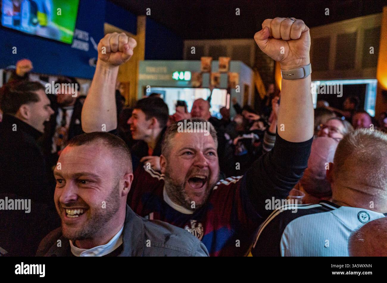 Dans un bar sportif de Marylebone, les fans de Newcastle United célèbrent joyeusement après que le défenseur Dan Burn ait mis leur camp en avant juste avant la mi-temps. Dans l'après-midi du 16 mars, des dizaines de milliers de fans de Newcastle United descendent. Wembley Way au stade de Wembley pour la finale de la Coupe de la Ligue de Carabao contre Liverpool. Sans une victoire de trophée domestique en 70 ans, la « Toon Army » marche sur la célèbre route avec excitation, espoir et pensées de victoire. Plus tard dans la journée, les fans de Newcastle sans billet regardent le match dans un événement du Sports Bar organisé par le supporter's Trust dirigé par les fans du club. Après un 1-2 vi Banque D'Images