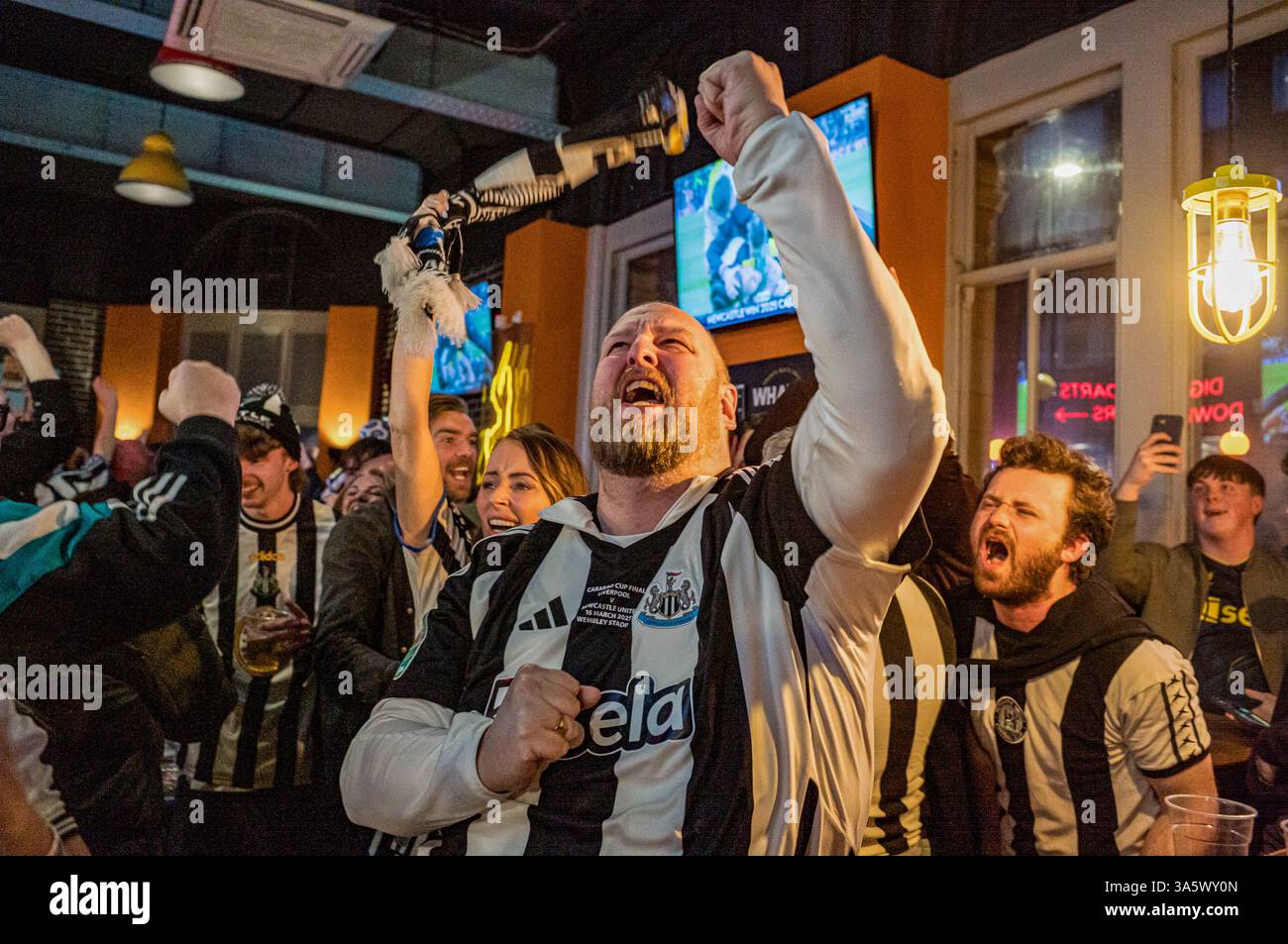 L'arbitre tire le coup de sifflet final, et dans un bar sportif Marylebone, les fans de Newcastle United célèbrent joyeusement leur équipe remportant la Coupe de la Ligue Carabao 2025. Dans l'après-midi du 16 mars, des dizaines de milliers de fans de Newcastle United descendent. Wembley Way au stade de Wembley pour la finale de la Coupe de la Ligue de Carabao contre Liverpool. Sans une victoire de trophée domestique en 70 ans, la « Toon Army » marche sur la célèbre route avec excitation, espoir et pensées de victoire. Plus tard dans la journée, les fans de Newcastle sans billet regardent le match dans un événement du Sports Bar organisé par les supporters du club Banque D'Images