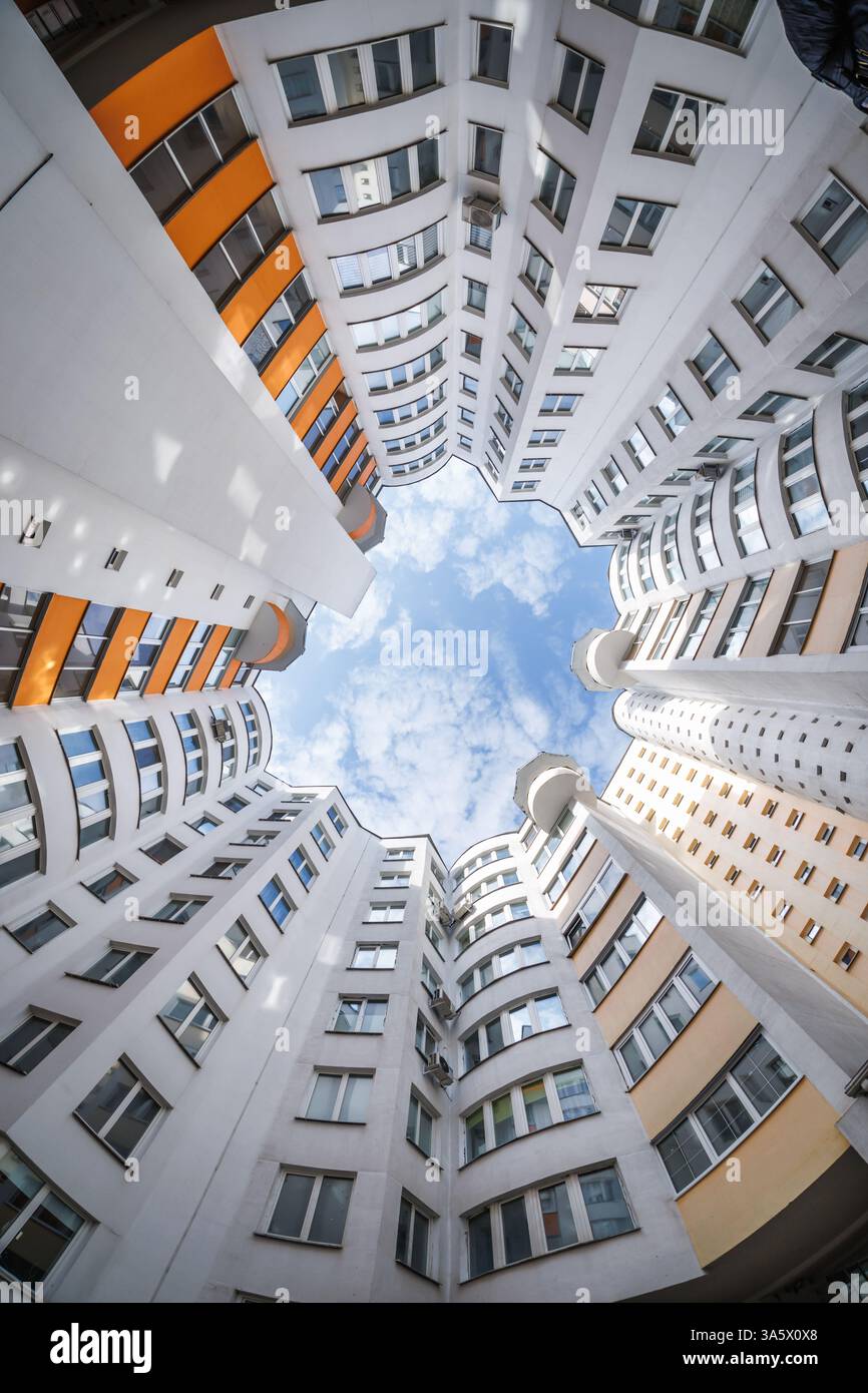 vue de bas en haut vers le ciel dans une maison gratte-ciel bien avec une cour étroite Banque D'Images