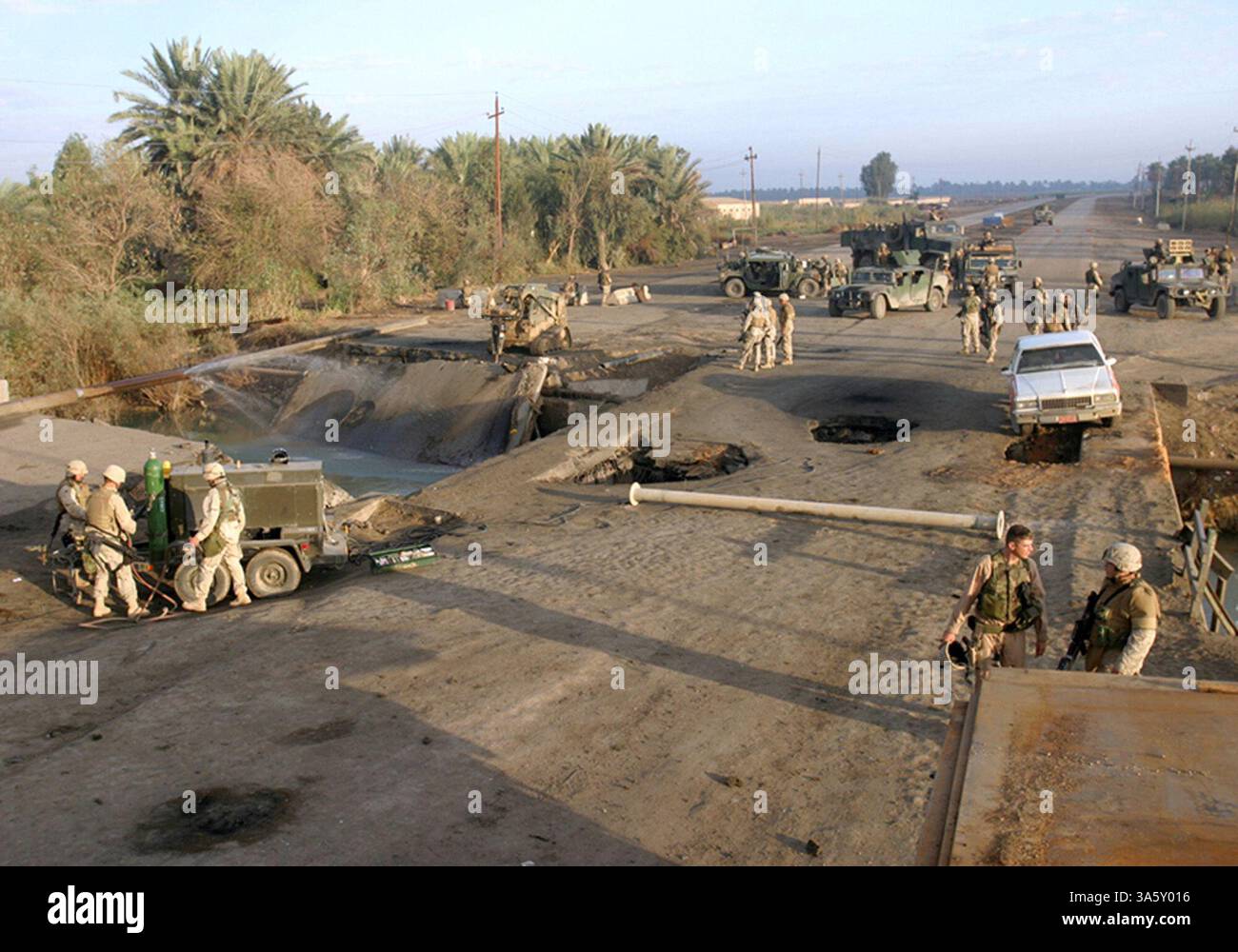 13 nov. 2004 ; Lutafiyah, IRAK ; des marins et des Marines affectés à la 24e unité expéditionnaire des Marines (24e MEU) examinent les restes d'un pont à Lutafiyah, Irak, avant de commencer les efforts de reconstruction. Le pont a été gravement endommagé lors d'attaques répétées de militants anti-irakiens. La 24e MEU mène actuellement des opérations de sécurité et de stabilité dans la province de Babil du Nord. Banque D'Images