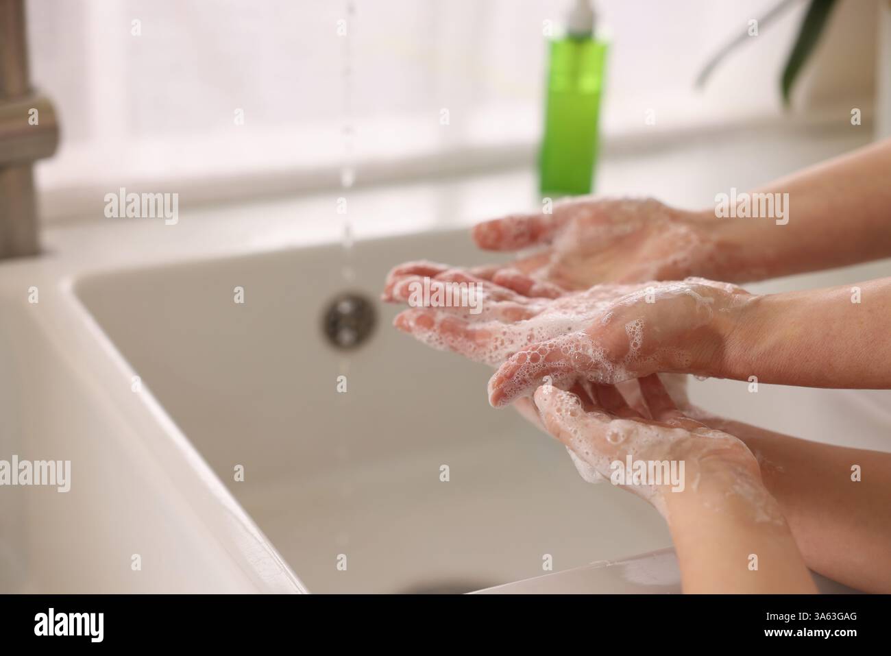Mère et fille se lavant les mains à l'intérieur, gros plan Banque D'Images