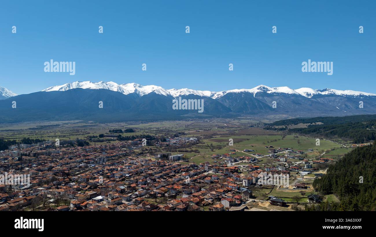 Panorama à couper le souffle sur la vibrante vallée de Razlog sous les montagnes de Pirin enneigées, soulignant la beauté printanière bulgare Banque D'Images