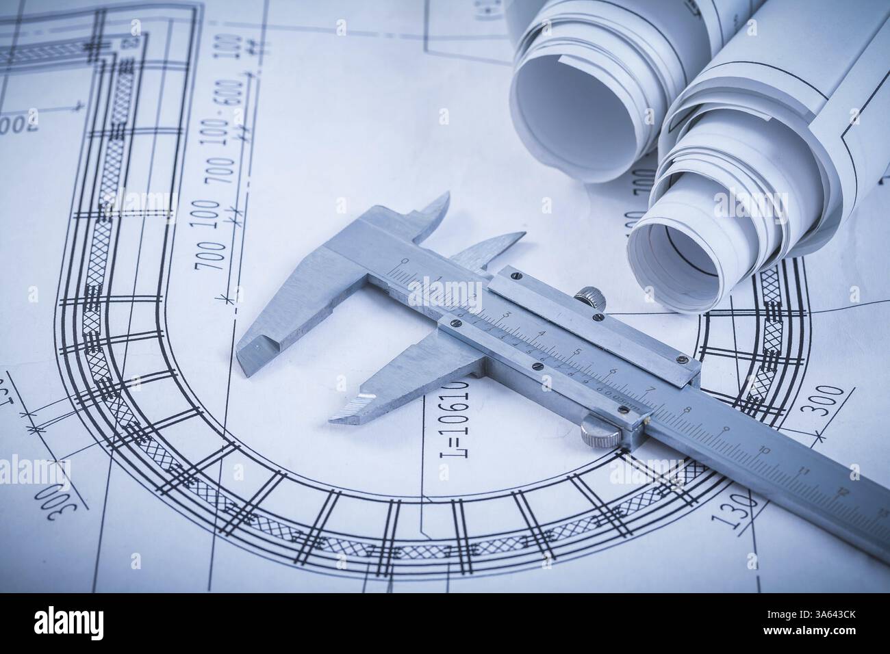 Dessins de construction roulés et pied à coulisse métallique sur le concept industriel Blueprint Banque D'Images
