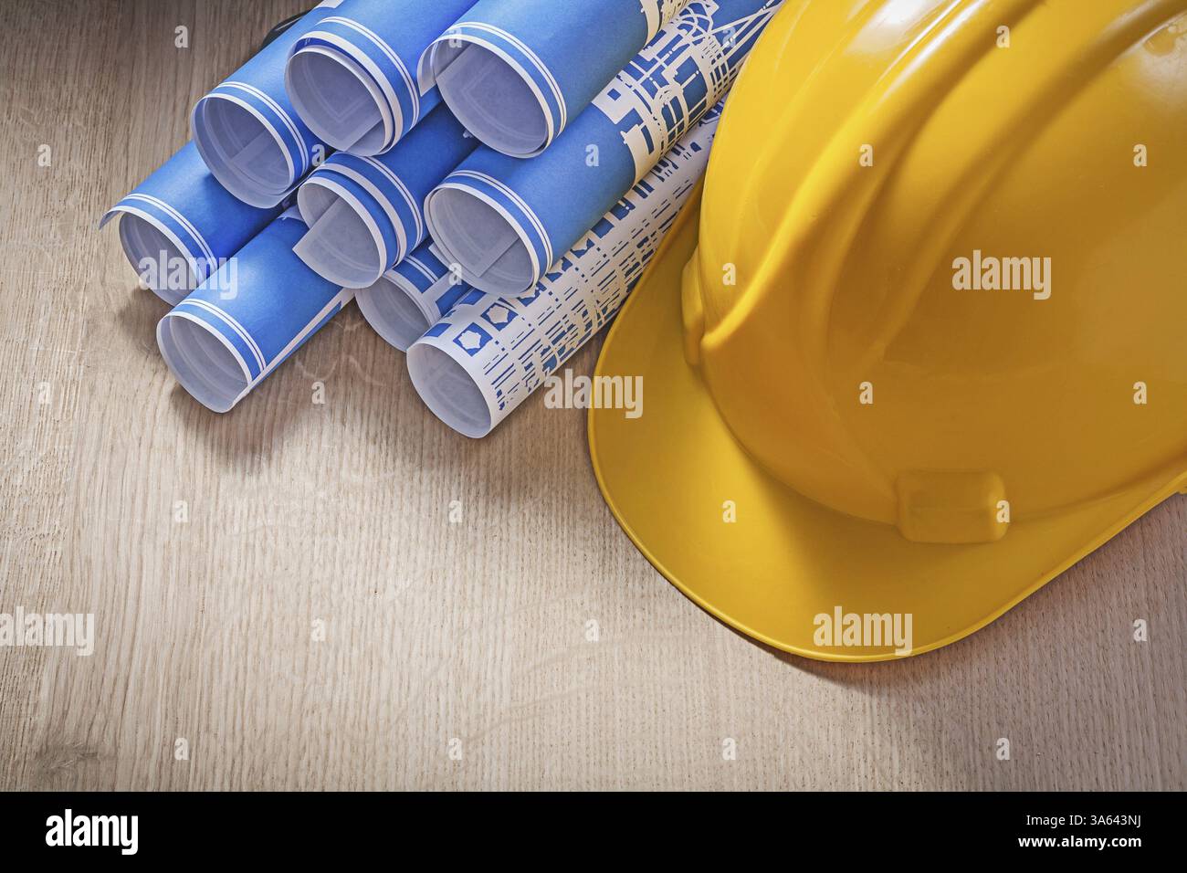Casquette de construction roulée bleue sur le concept de maintenance de planche en bois Banque D'Images