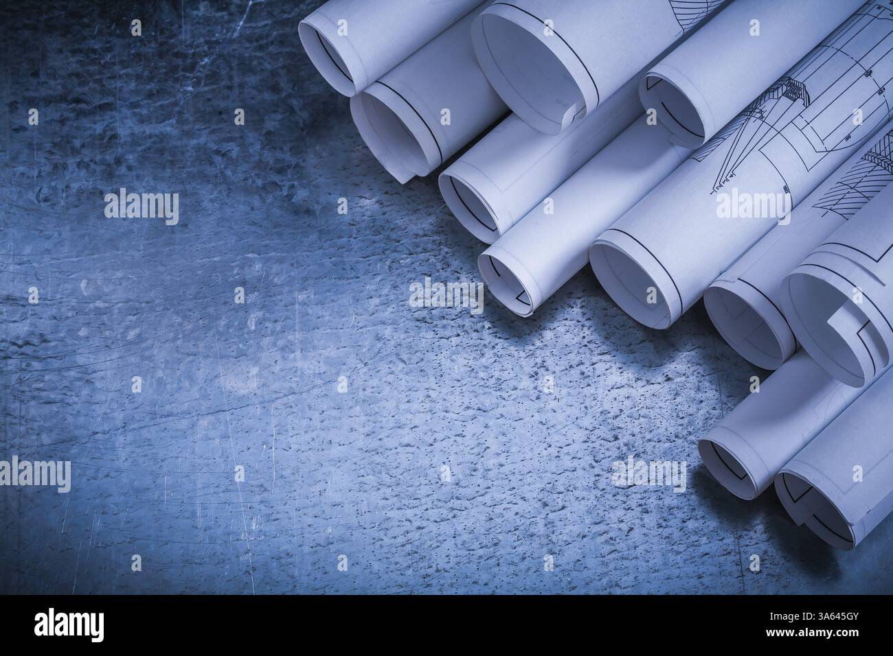 Dessins de construction architecturaux roulés sur le bâtiment de surface argentée vintage rayé et concept d'architecture Banque D'Images