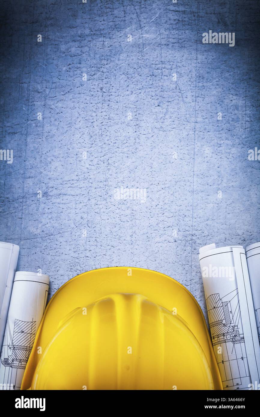 Plans architecturaux avec casque de protection sur le concept de construction de surface rayée vintage en argent-métal Banque D'Images