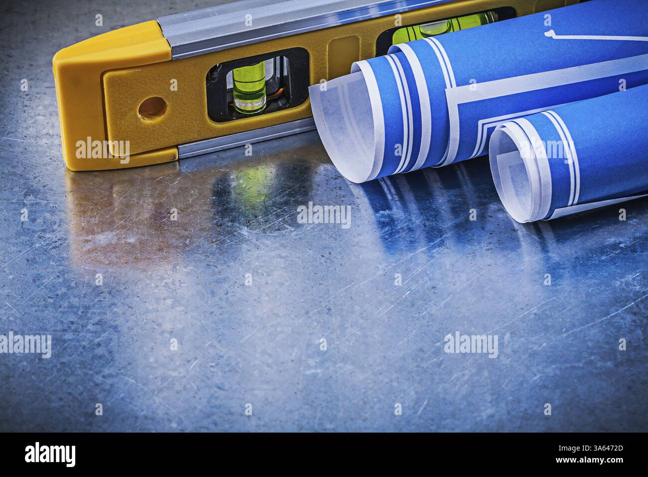 Niveau de construction des dessins techniques enroulés sur fond métallique rayé Banque D'Images