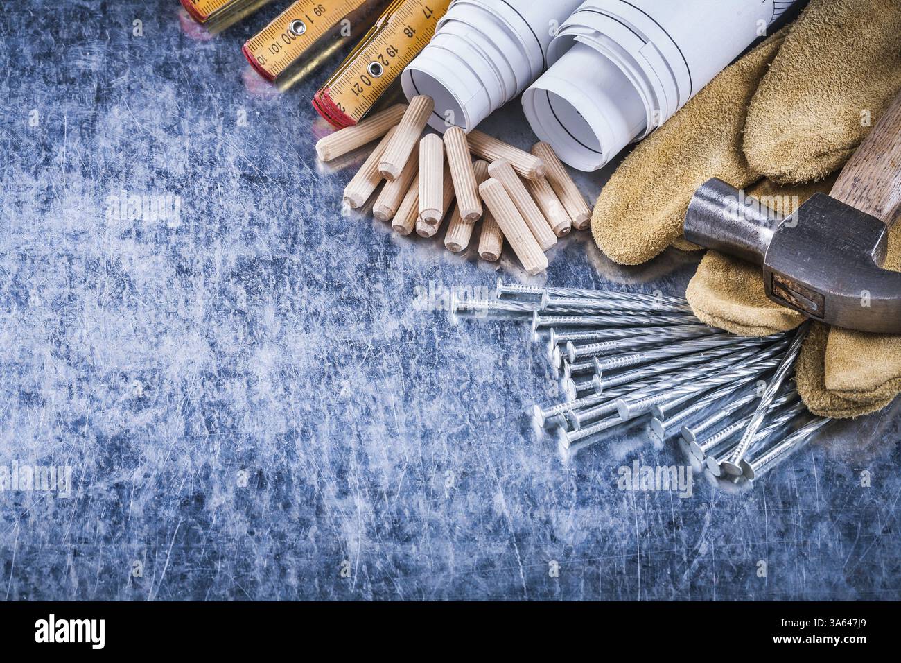 Blueprints marteau gants de sécurité en bois construction de mètres clous et tas de chevilles sur le concept d'entretien de surface métallique rayée Banque D'Images
