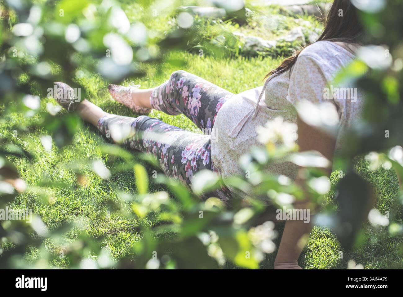 Les femmes enceintes dans le jardin. L'herbe verte Banque D'Images