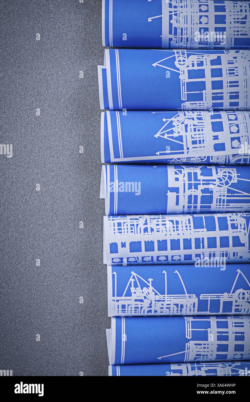 Dessins de construction roulés bleus sur fond gris vue de dessus concept de maintenance Banque D'Images