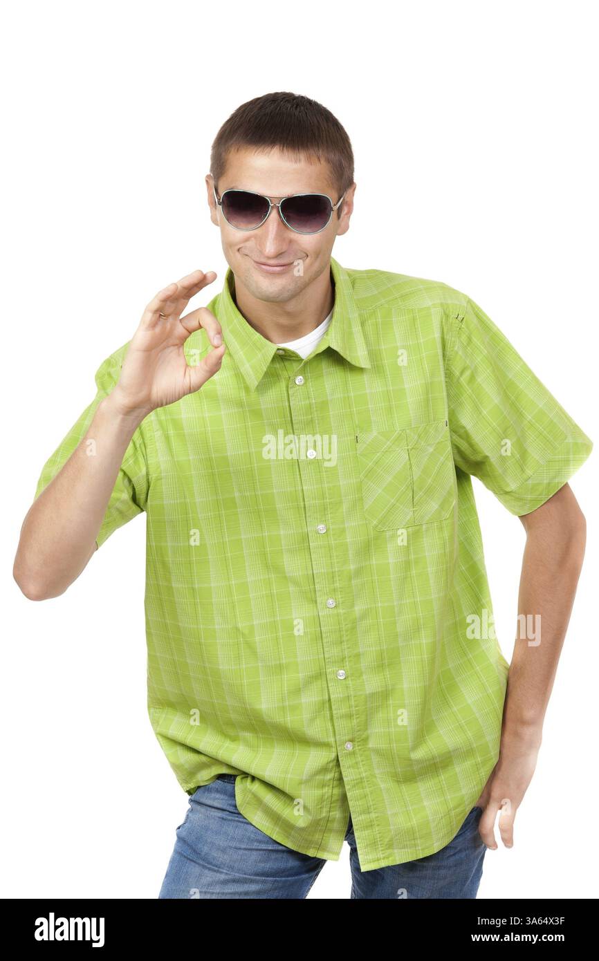 Smiling Young man with sunglasses portant chemise à carreaux montre symbole ok. Isolé sur fond blanc, masque inclus Banque D'Images