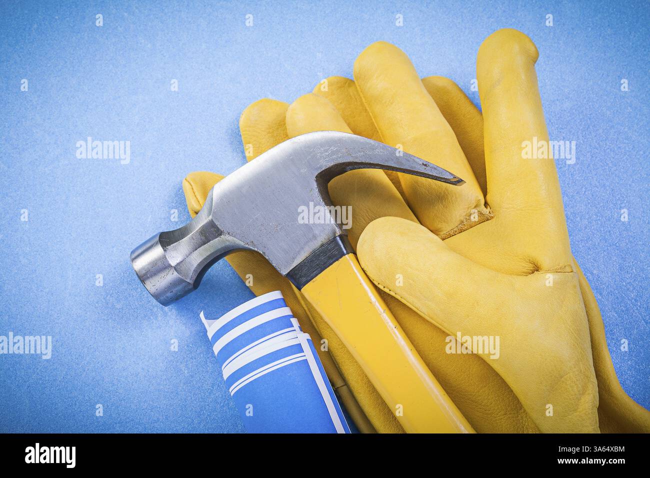 Les gants de sécurité de marteau à griffes ont roulé des dessins de construction sur fond bleu Banque D'Images