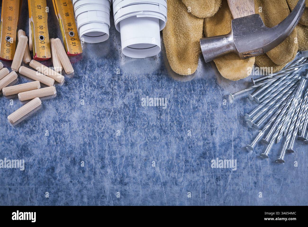 Blueprints griffes marteau gants de protection en cuir mètre en bois clous en acier et chevilles sur le concept de construction de fond métallique rayé Banque D'Images