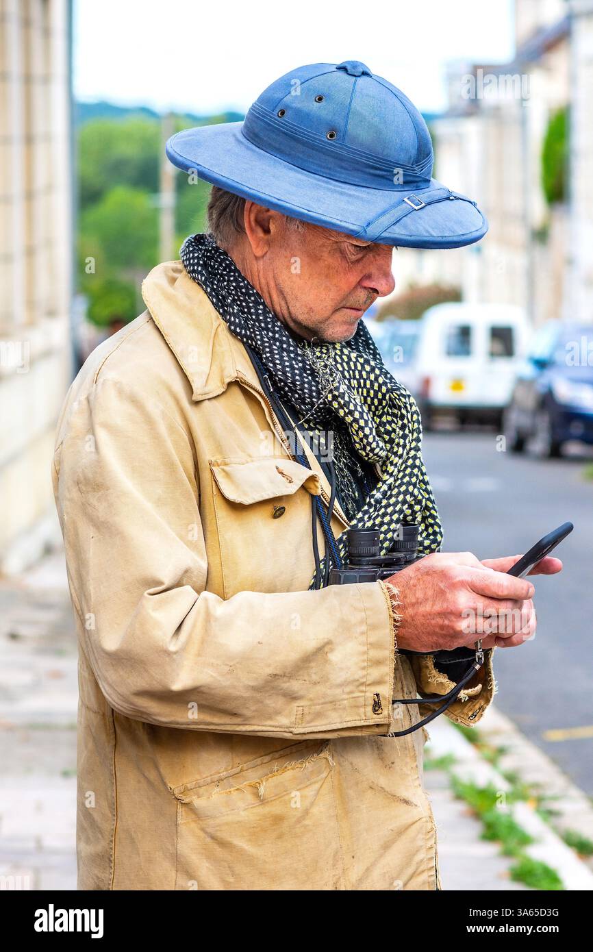 Homme en casque à moelle bleue regardant smartphone - Preuilly-sur-Claise, Indre-et-Loire (37), France. Banque D'Images