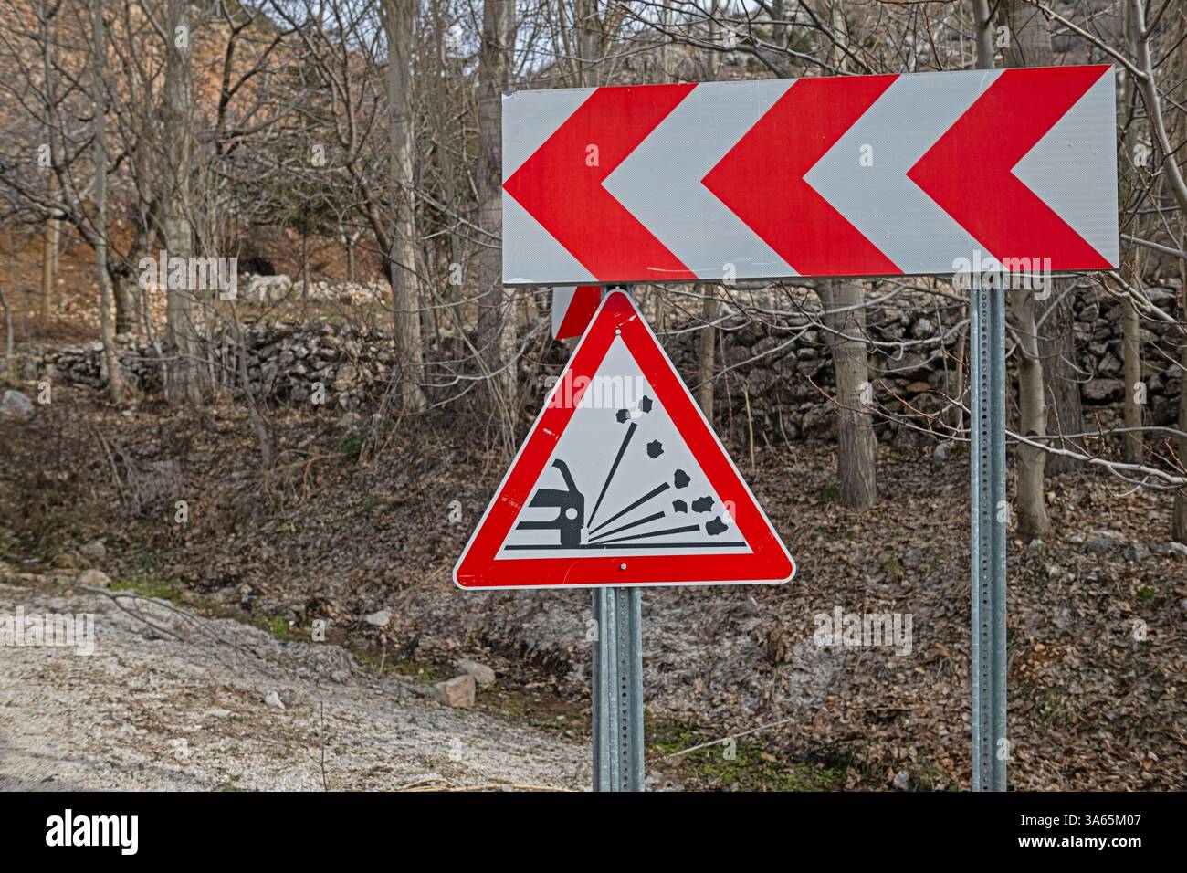 Panneaux de signalisation routière avertissant de virage à gauche et d'éclaboussures de pierres. Banque D'Images