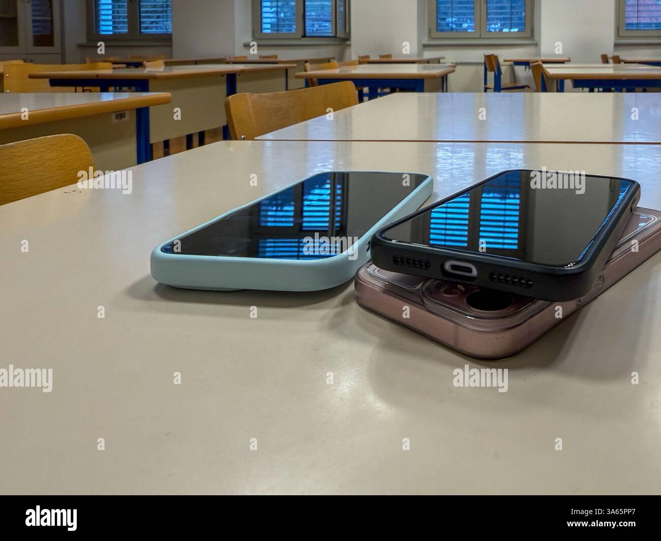 Pile de smartphones sur le bureau en classe – symbole d'interdiction de téléphone Banque D'Images