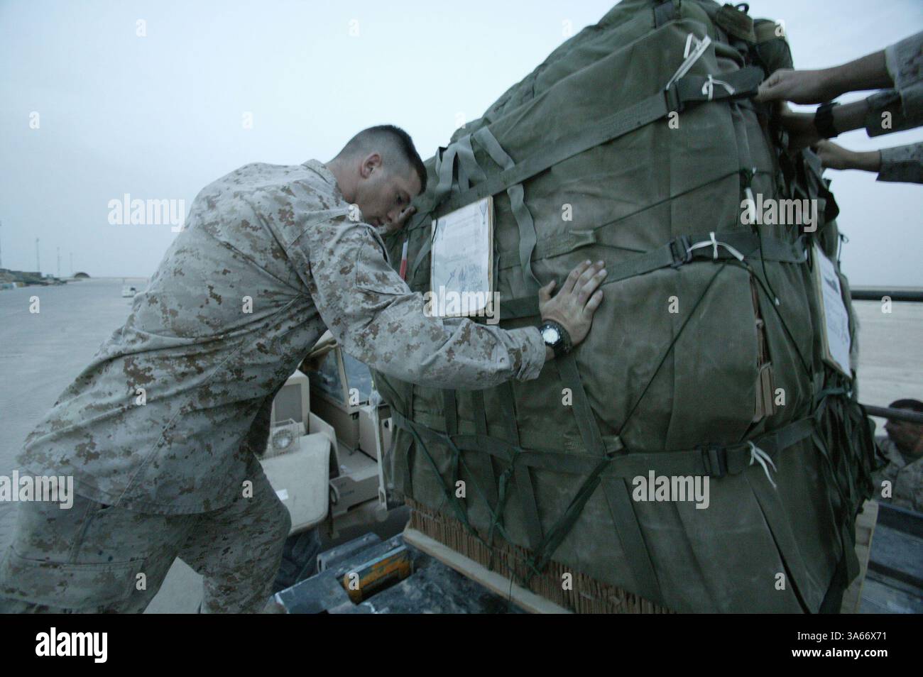 19 mai 2004 ; Camp Al Asad, Irak ; lance le Cpl CARL J. Myers, gréeur de parachutistes du peloton de livraison aérienne, bataillon de soutien des services de combat 7, aide à positionner une palette de fret au Camp Al Asad, Irak, le 19 mai 2004. Seize palettes chargées de 22 000 livres de nourriture et d'eau ont été larguées à des Marines opérant dans l'ouest de l'Irak le 20 mai 2004. La mission était le premier largage d'approvisionnement aérien de combat effectué depuis le retour des Marines en Irak cette année. CSSB-7 fait partie du Groupe de soutien des services de la 1re Force. Myers, 21 ans, est originaire de Mahopac, New York. Banque D'Images