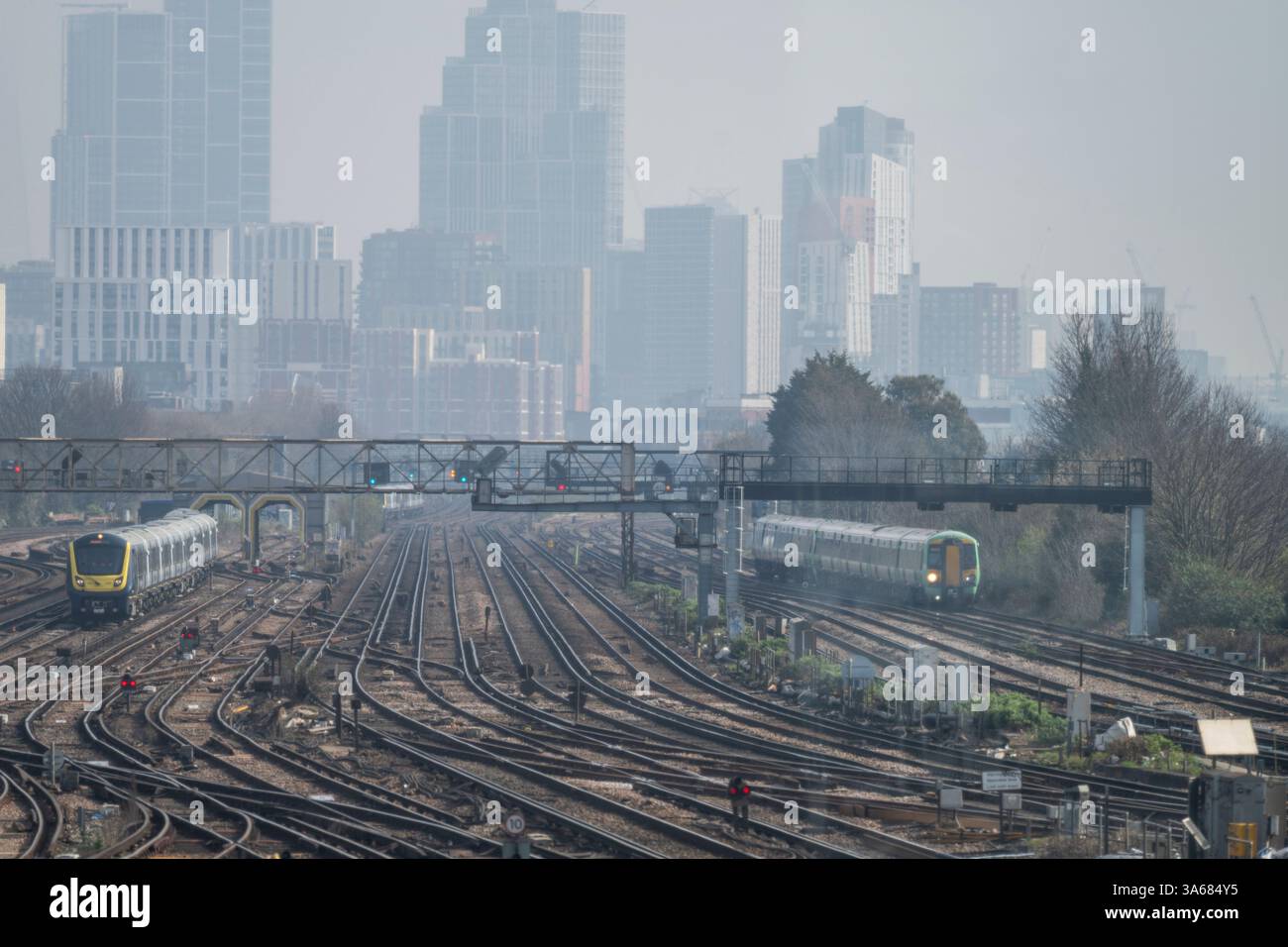 Londres, Royaume-Uni. 25 mars 2025. South Western Railway sera la première compagnie ferroviaire à être ramenée à la propriété publique par le gouvernement travailliste en mai 2025. South West propose de nombreux services de banlieue locaux et des trains longue distance au départ de la gare de Waterloo à Londres. Image : South West Class 701 Express (à gauche) à Clapham Junction. Crédit : Malcolm Park/Alamy Live News Banque D'Images