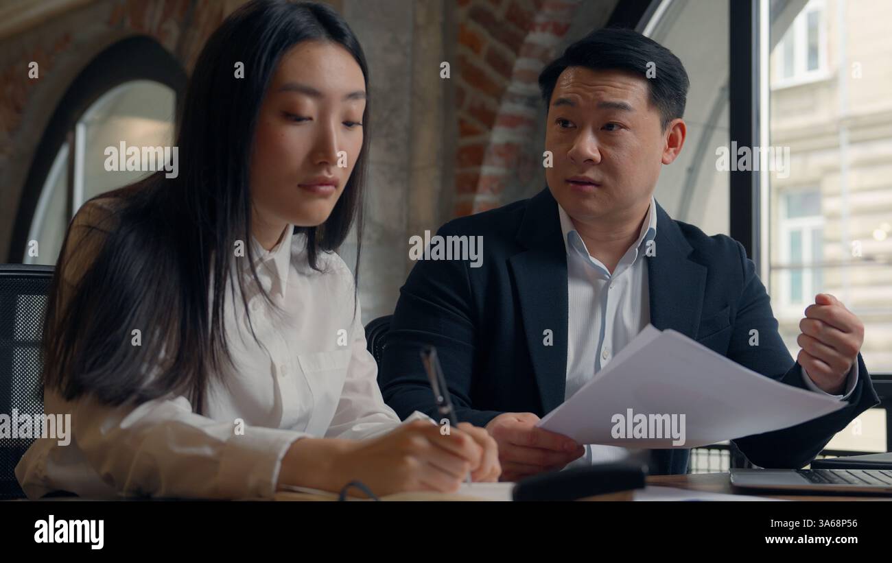 Problèmes d'affaires collègues dans le bureau se plaignent patron insatisfait homme asiatique homme d'affaires coréen chef parler des documents d'ordinateur portable erreur triste japonais Banque D'Images