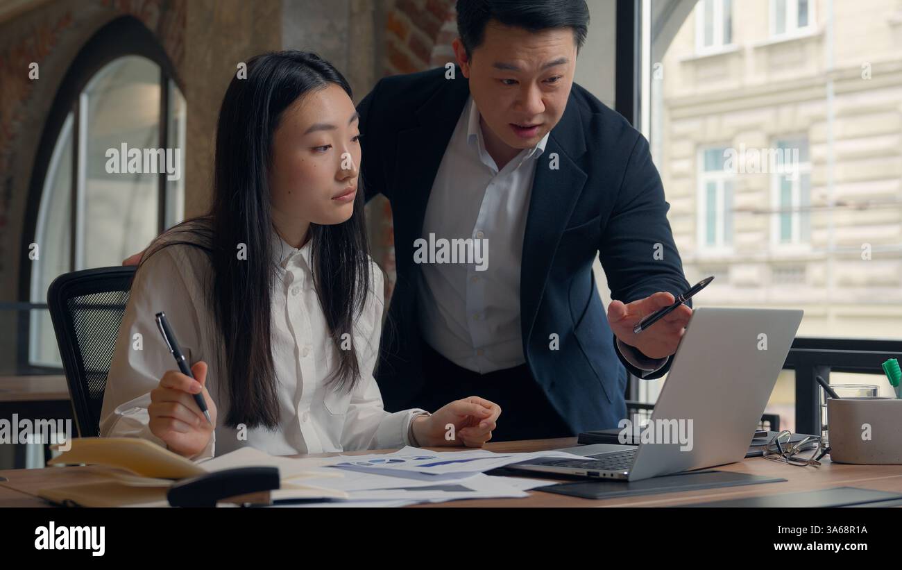 Deux directeurs d'entreprise collègues des collègues asiatiques travaillent ensemble des documents de travail d'équipe analysent la femme chinoise fille femme d'affaires japonaise homme coréen Banque D'Images