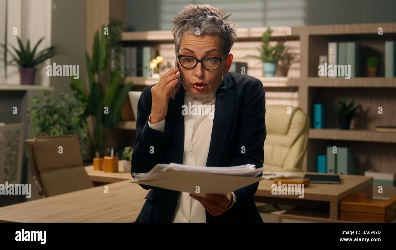Au bureau en colère fou vieux caucasien femme d'affaires femme d'affaires femme d'affaires mature employeur senior moyen-Age PDG entrepreneur parlant appel de téléphone mobile Banque D'Images