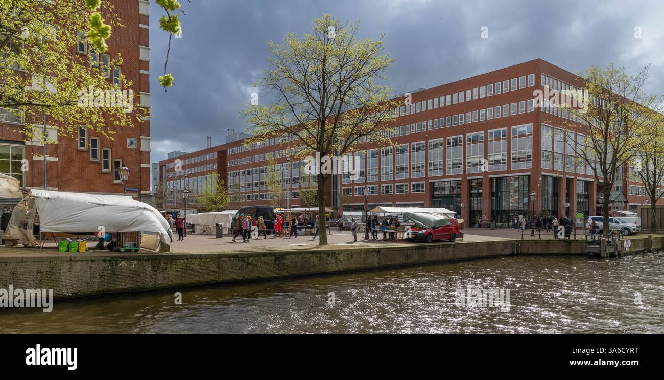 Le canal de Zwanenburgwal et le marché aux puces Waterlooplein un samedi pluvieux. Banque D'Images