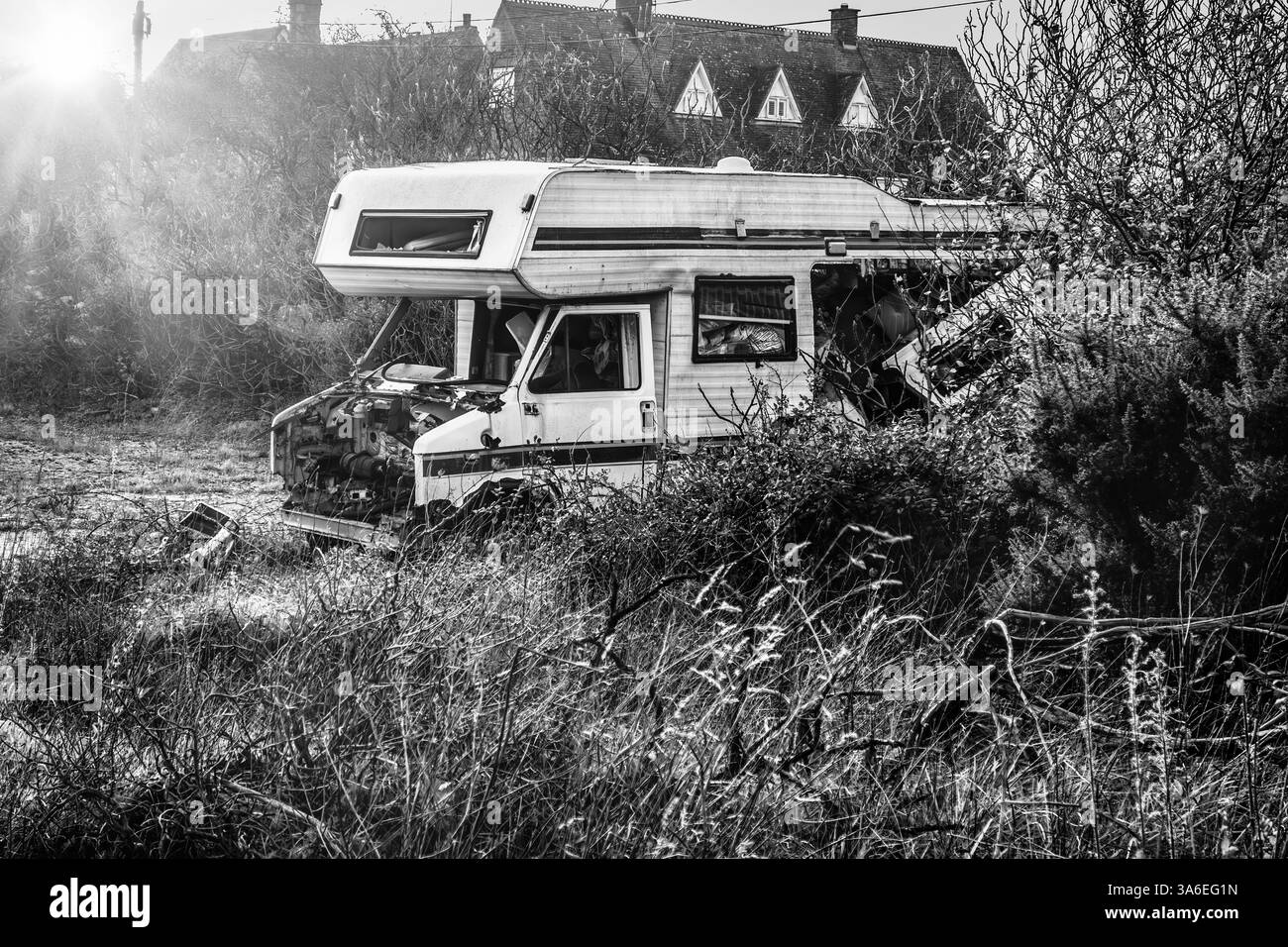 Un camping-car naufragé abandonné dans un champ à l'atmosphère sombre, situé à Rye, Sussex Angleterre, Royaume-Uni, dans un ton noir et blanc Banque D'Images